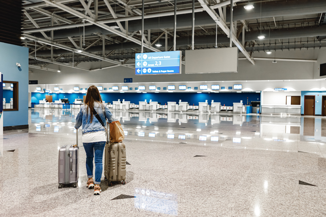 Woman walks along the airport with two suitcases